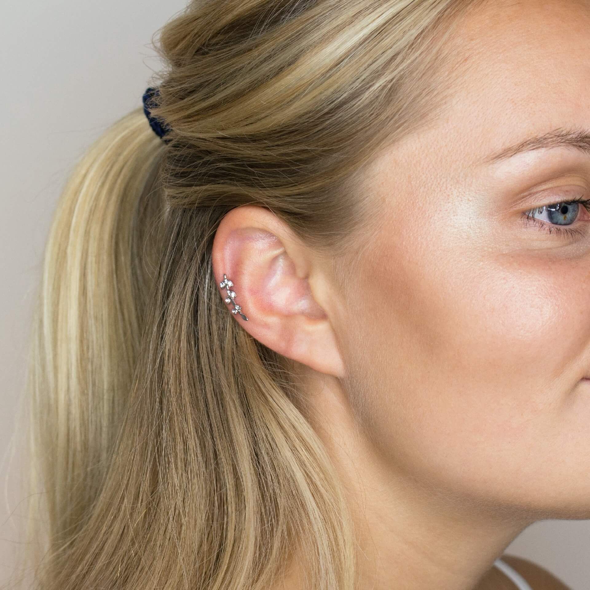 Oorpiercing met bladeren uit steentjes