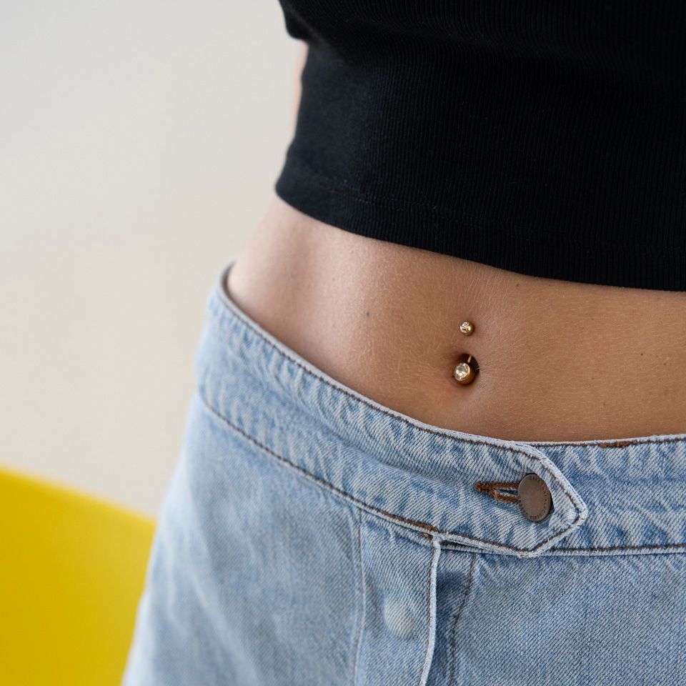 Vergulde navelpiercing met steentjes