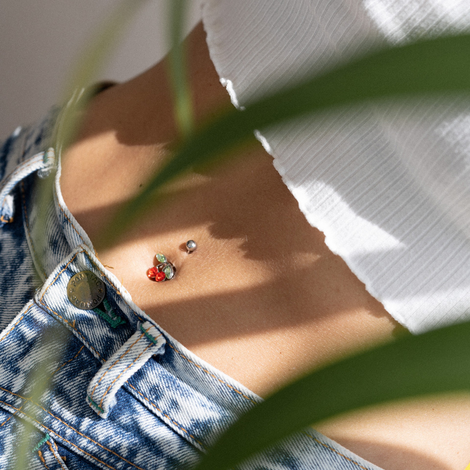 Navelpiercing met een rode kers