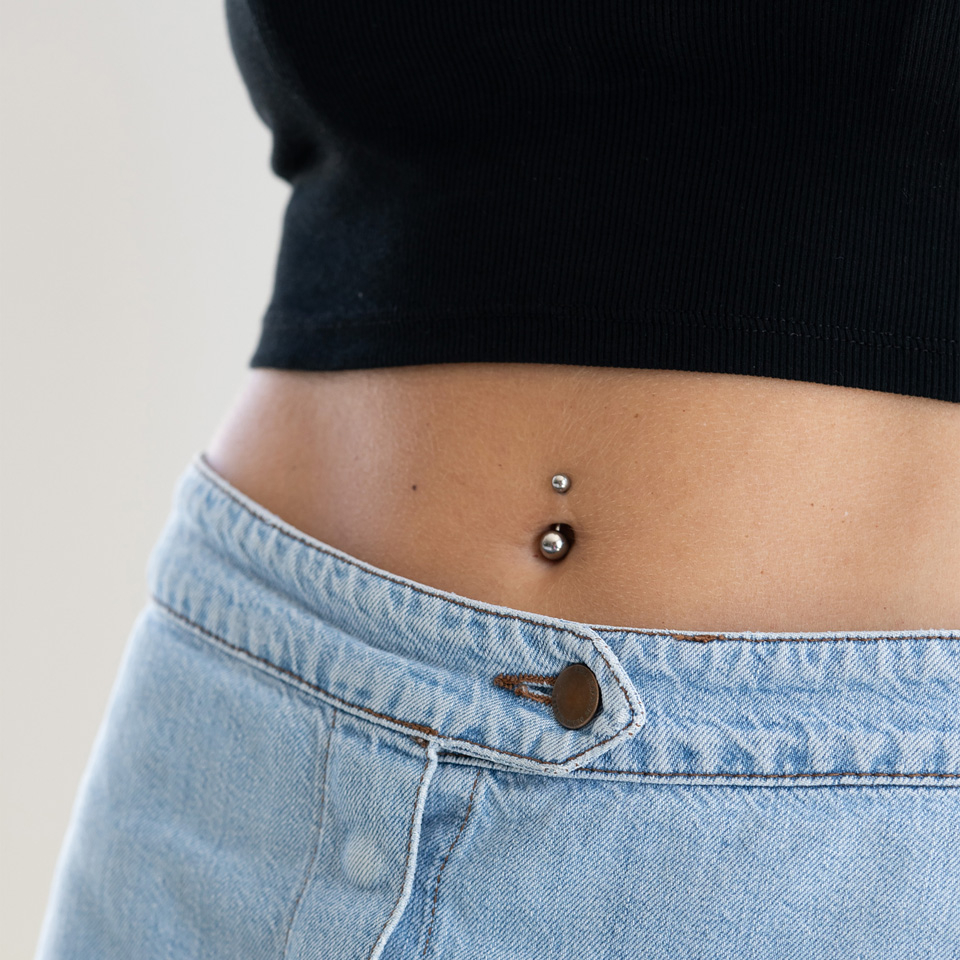 Vergulde navelpiercing met een grote steen